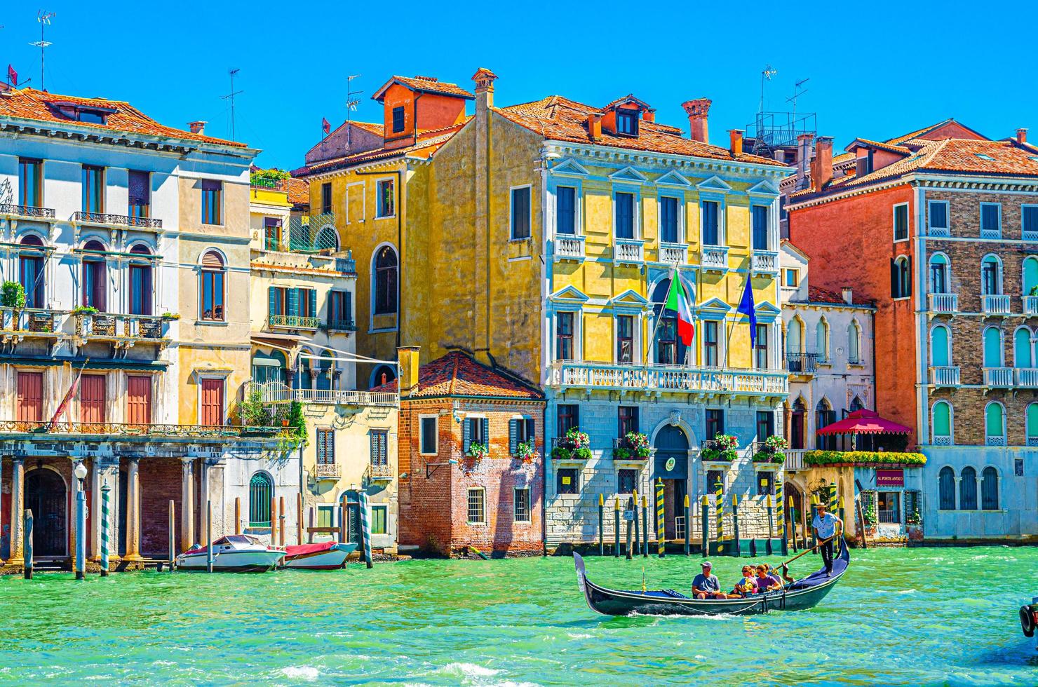 gondolier och turister på gondol traditionell båt som seglar på vattnet i Canal Grande i Venedig foto