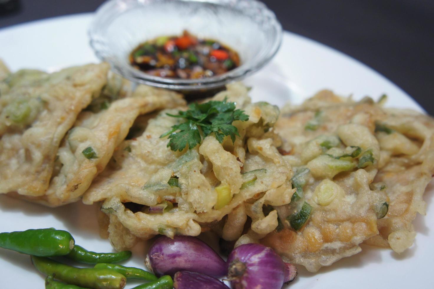 en traditionell javanesisk, indonesisk mat gjord av tempeh belagd med mjöl och halvstekt salladslök kallas tempe mendoan foto