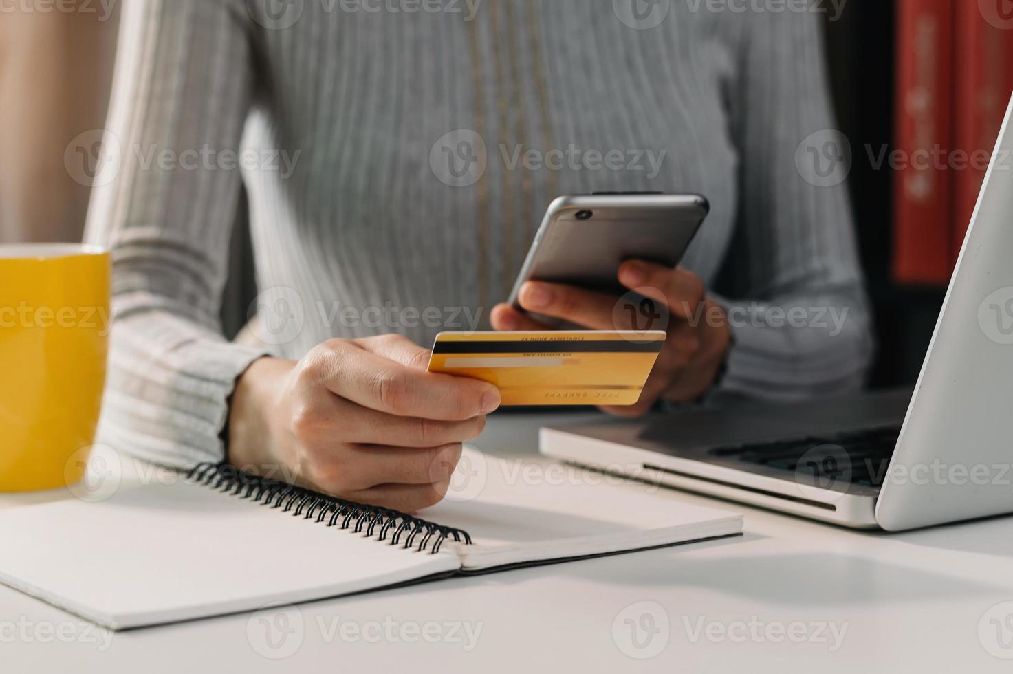 kvinna som använder smart telefon för mobilbetalningar onlineshopping, omni-kanal, sitter på bordet, virtuella ikoner grafikgränssnittsskärm foto