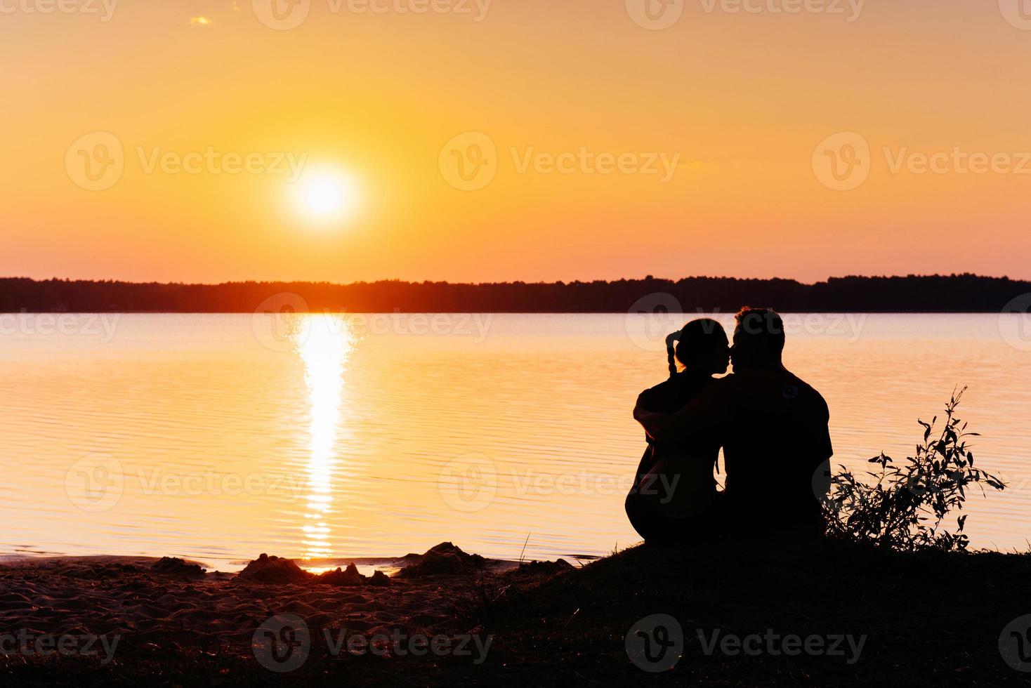 romantiskt par på stranden vid färgglad solnedgång på bakgrunden foto