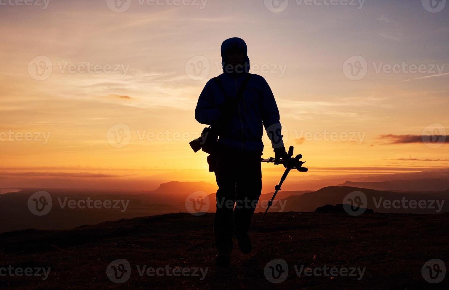 naturfotograf med digitalkamera på toppen av berget. foto