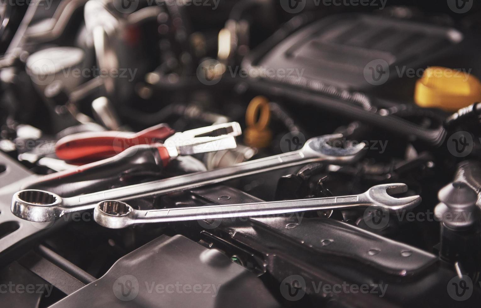mekaniker handkontrollerar och fixar en trasig bil i bilservicegarage foto