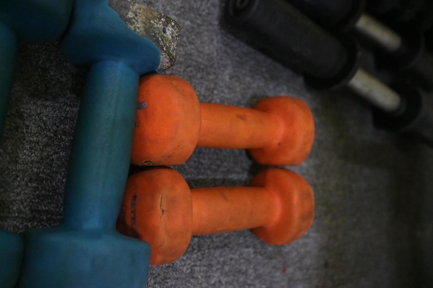 redaktionell bild av några blåorange hantlar på mattan för att träna i gymmet foto