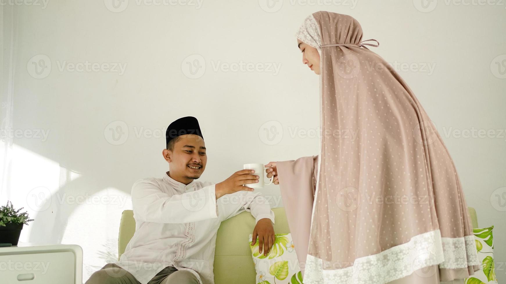 muslimsk kvinna ger sin man ett glas drink foto