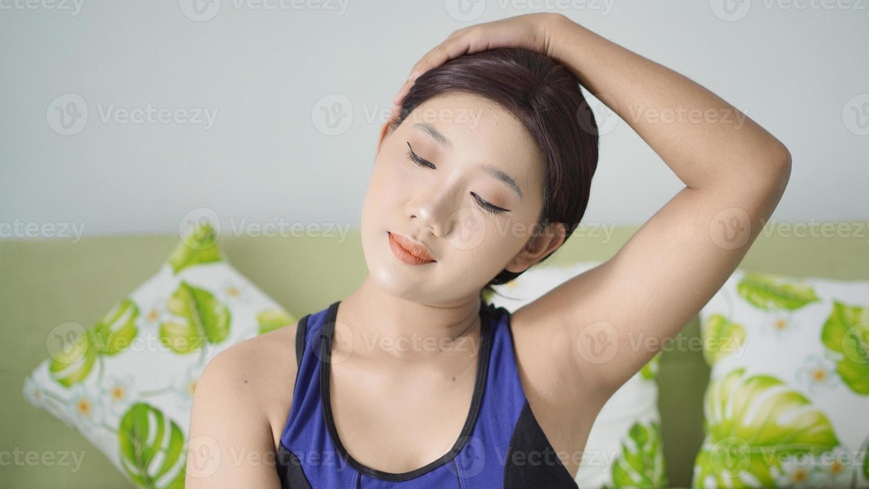 asiatisk kvinna yoga hemma värmer upp head to side foto