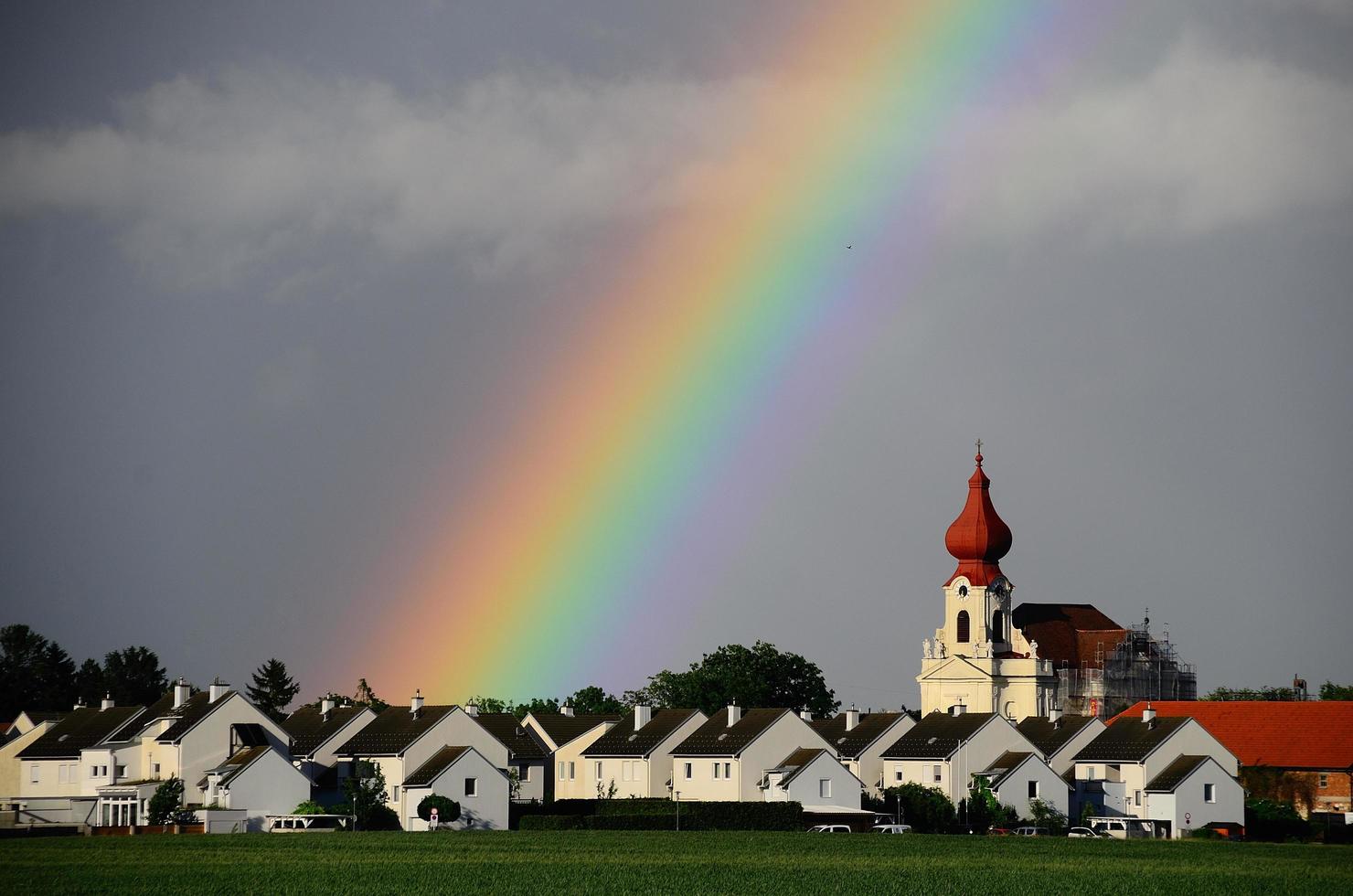 regnbåge i byn med kyrkan foto