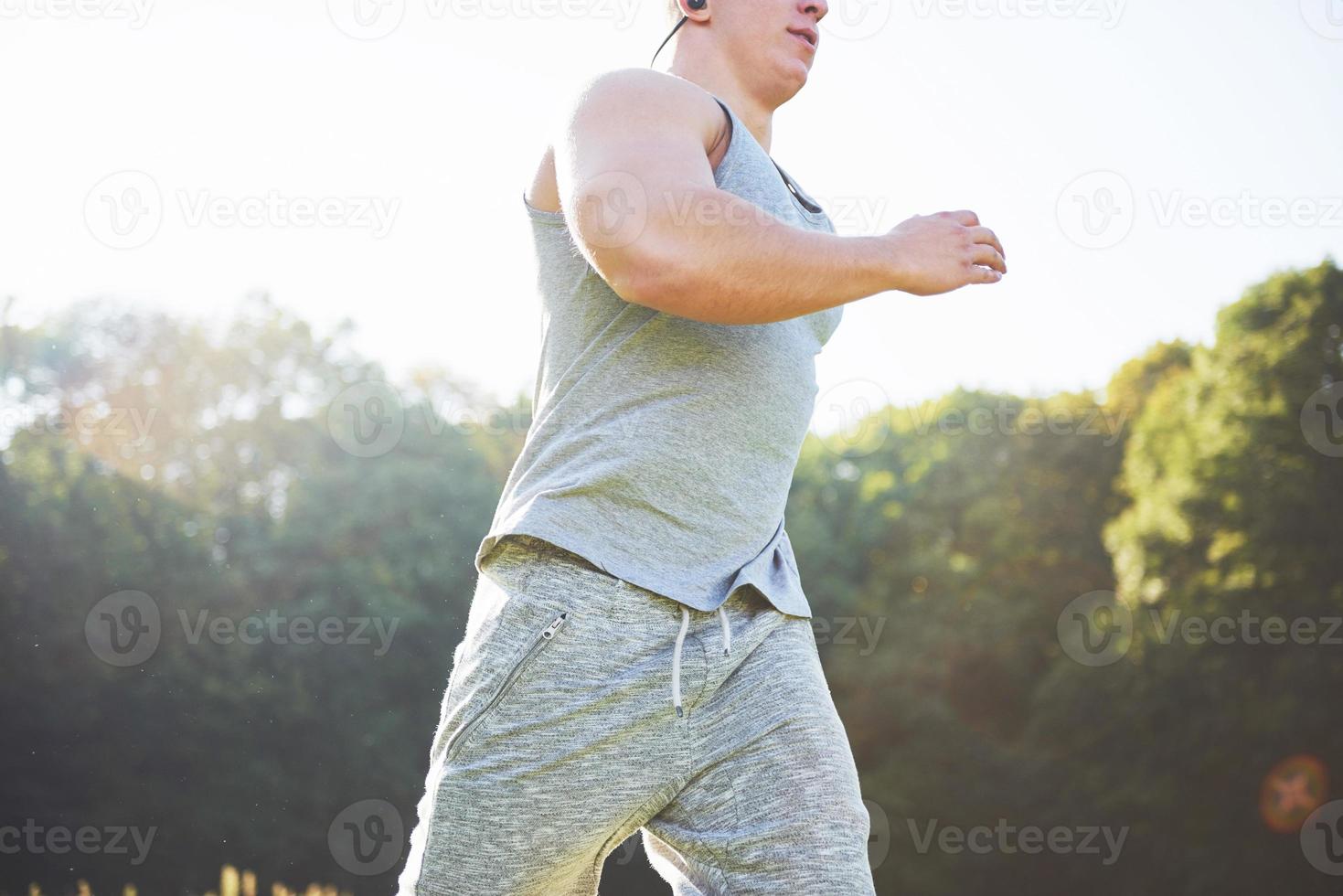 fitness man idrottare joggar i naturen under solnedgången. person som springer och tränar och lever en aktiv livsstil, tränar konditionsträning på sommaren i sportkläder och skor. foto