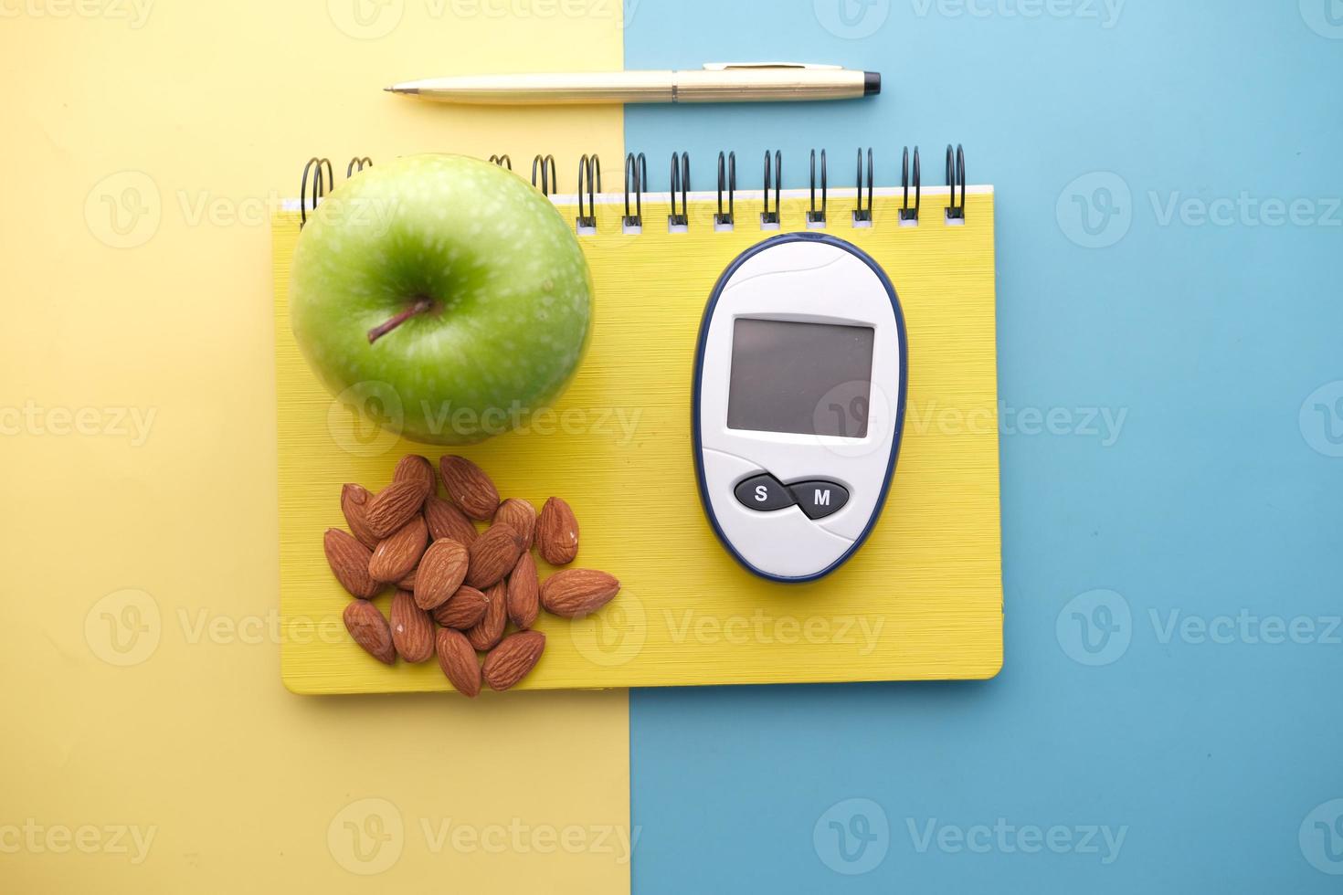 diabetiska mätverktyg, mandelnötter, äpple på färgbakgrund foto