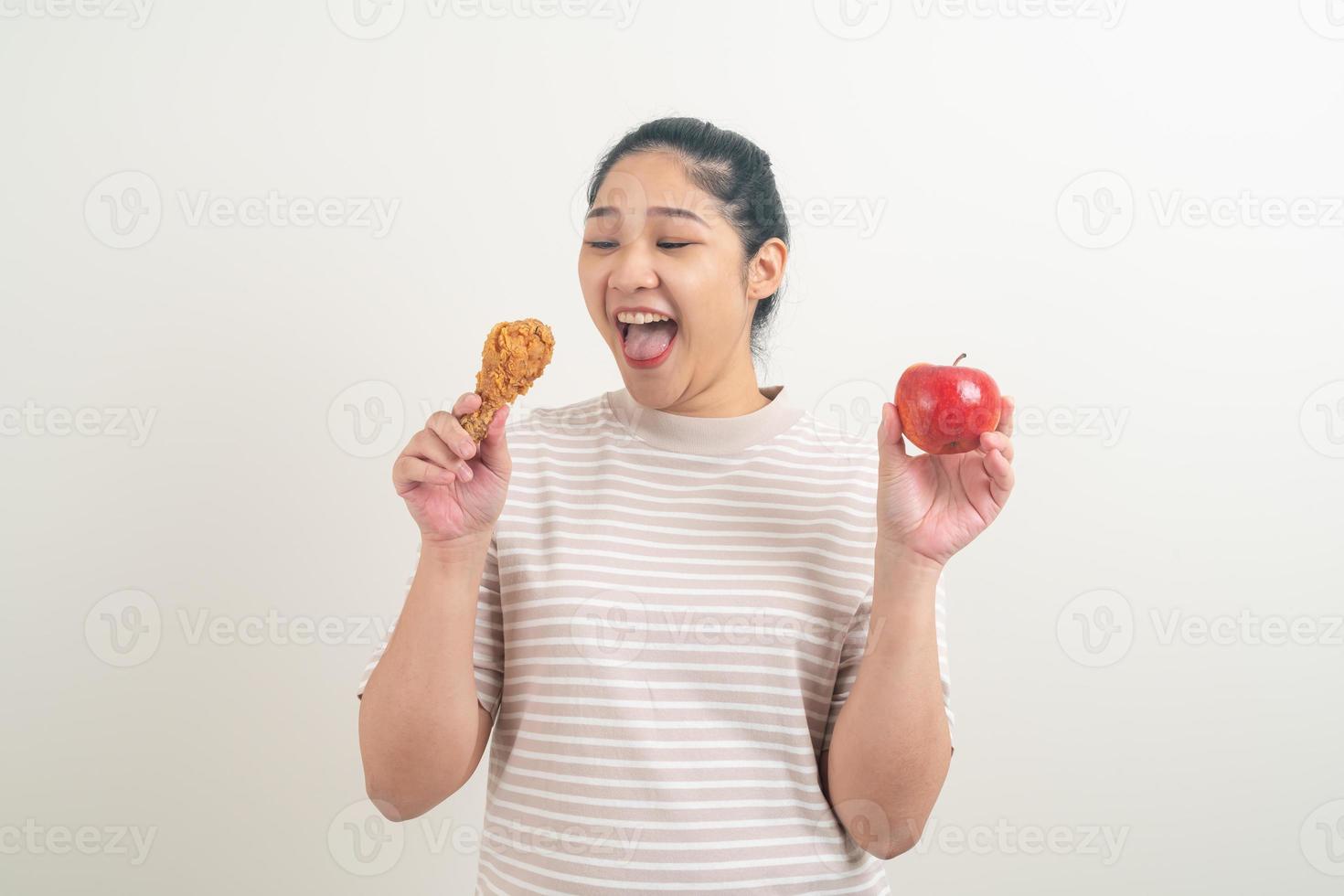 asiatisk kvinna med stekt kyckling och äpple till hands foto