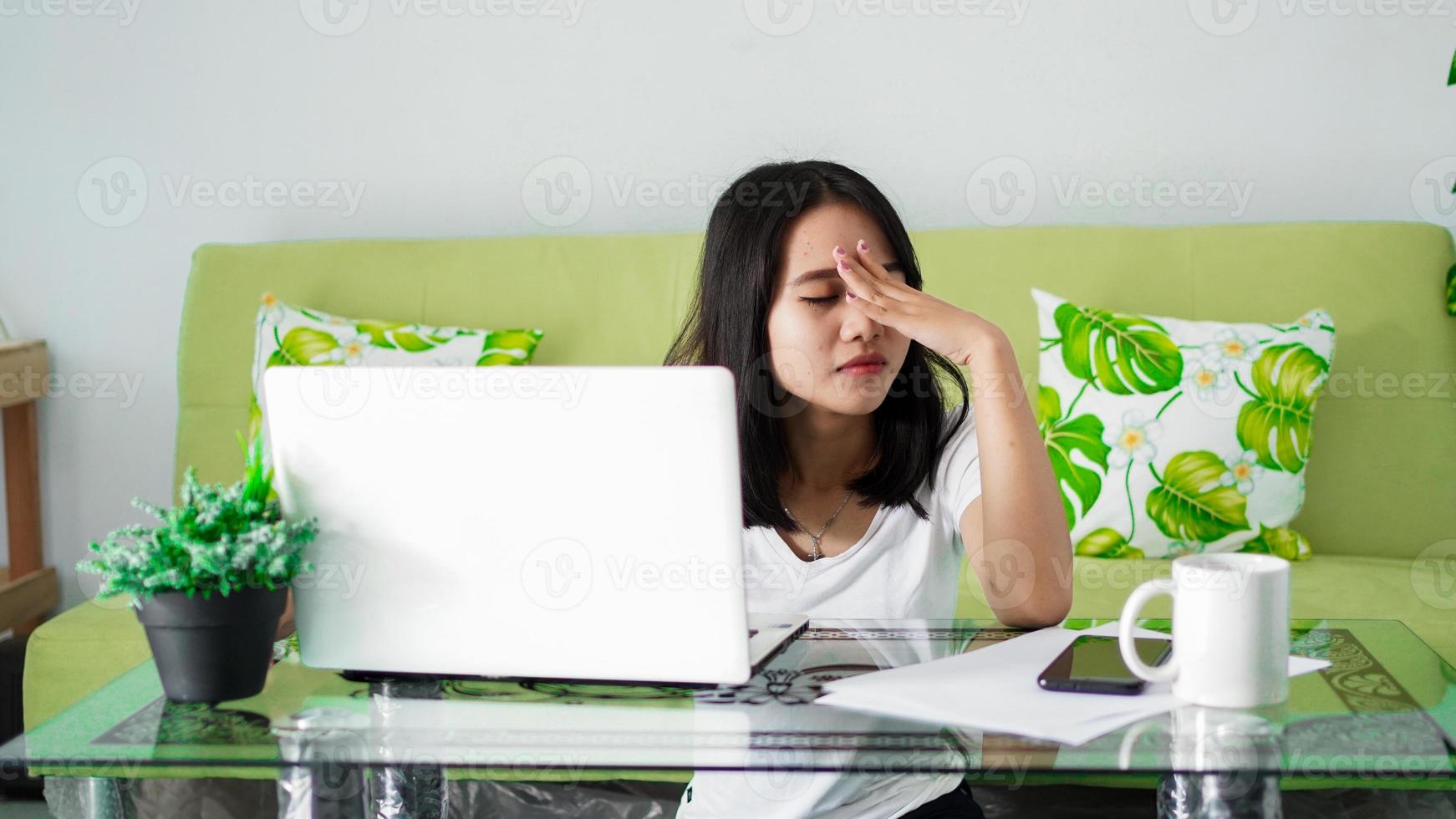 stressad asien kvinna arbeta hemifrån med datorn hemma foto