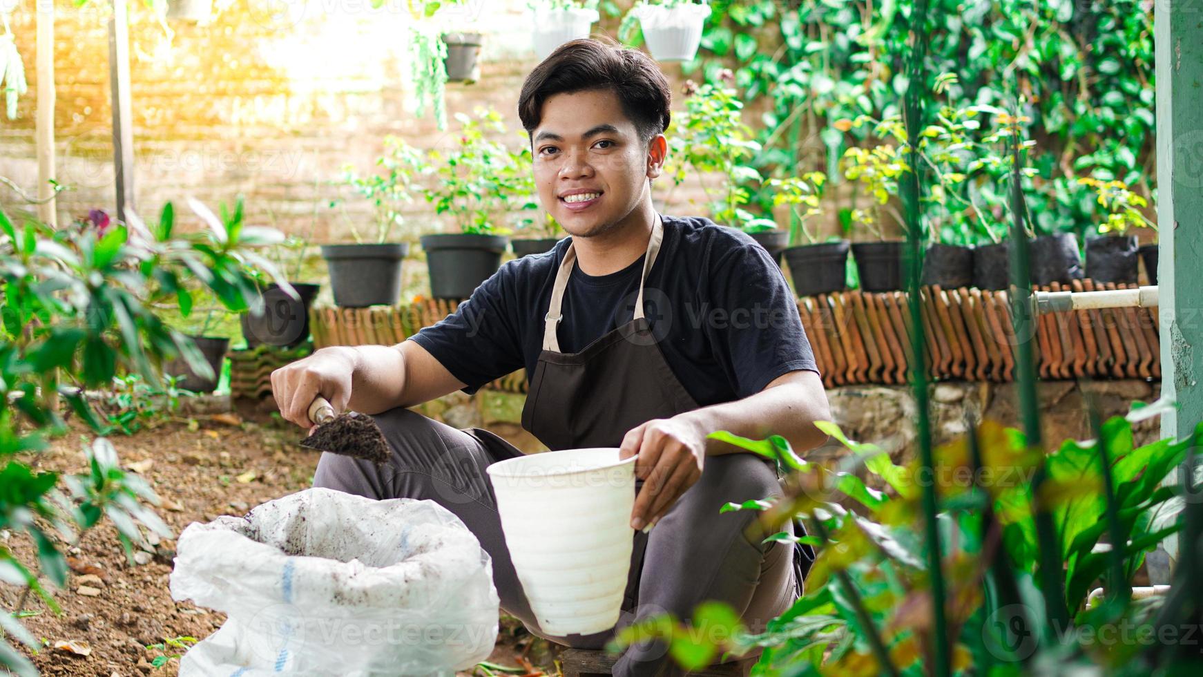 asiatisk man förbereda en plats för plantering med kruka och jord foto