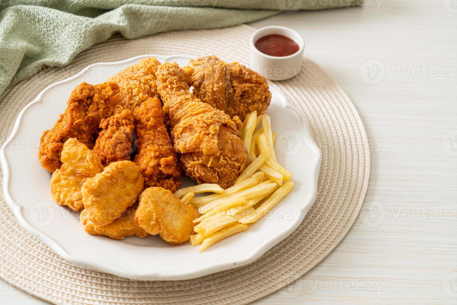 stekt kyckling med pommes frites och nuggets på tallrik foto