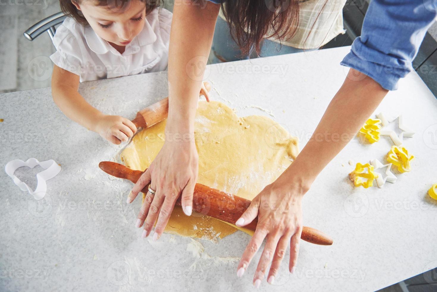lycklig familj förberedelse semester mat koncept. familjen lagar julkakor. händerna på mor och dotter som förbereder degen på bordet. lycklig familj i att göra kakor hemma foto