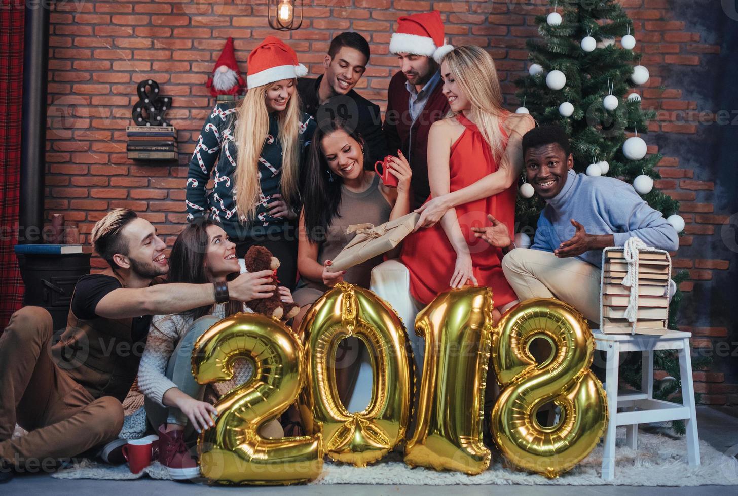 grupp glada gamla vänner kommunicerar med varandra. nytt år 2018 kommer. fira in det nya året i en mysig hemmiljö foto