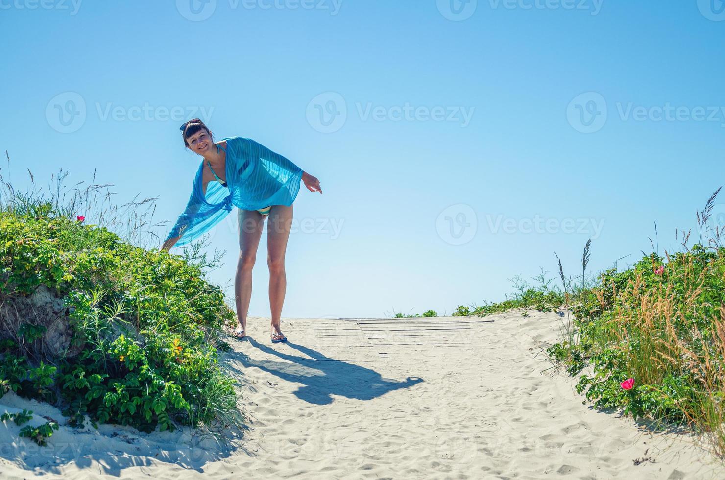 ung vacker flicka i bikini, pareo wrap och solglasögon på huvudet poserar foto