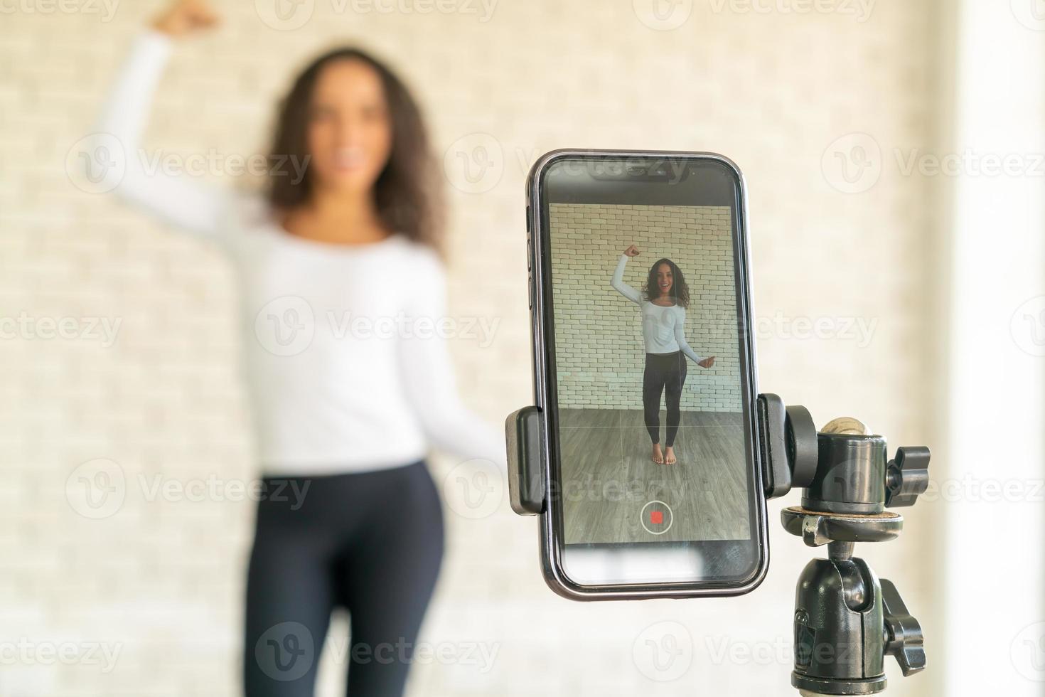 latinsk kvinna skapade sin dansvideo med smartphonekamera. för att dela video till sociala medier-applikationer. foto