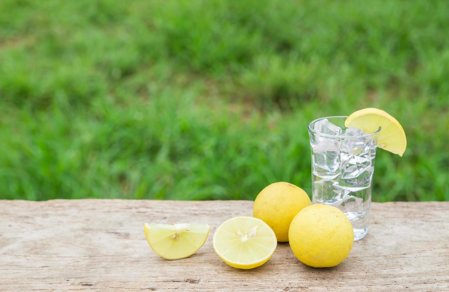 vodka med citron på trä bakgrund foto