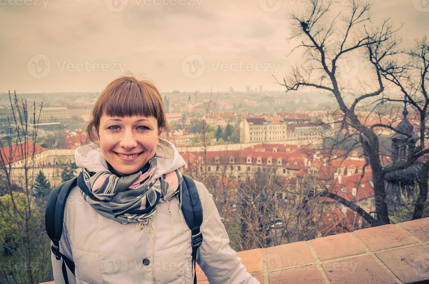 närbild porträtt av ung kaukasisk flicka resenär med vit jacka tittar på kameran och leende foto