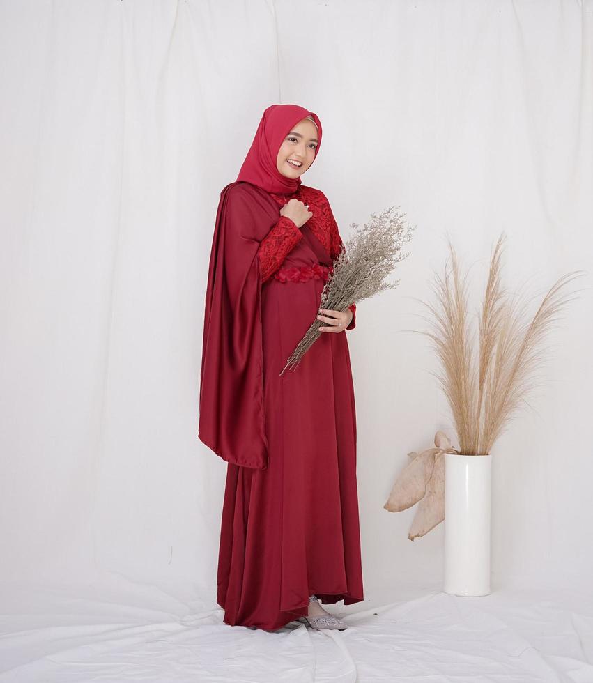 vacker islamisk kvinnlig modell som bär hijabmode, en modern livsstilsoutfit för muslimsk kvinna. koncept en bröllopsklänning, skönhet eller eidul fitri. en asiatisk tjejmodell som bär hijab på inomhusfotografering foto