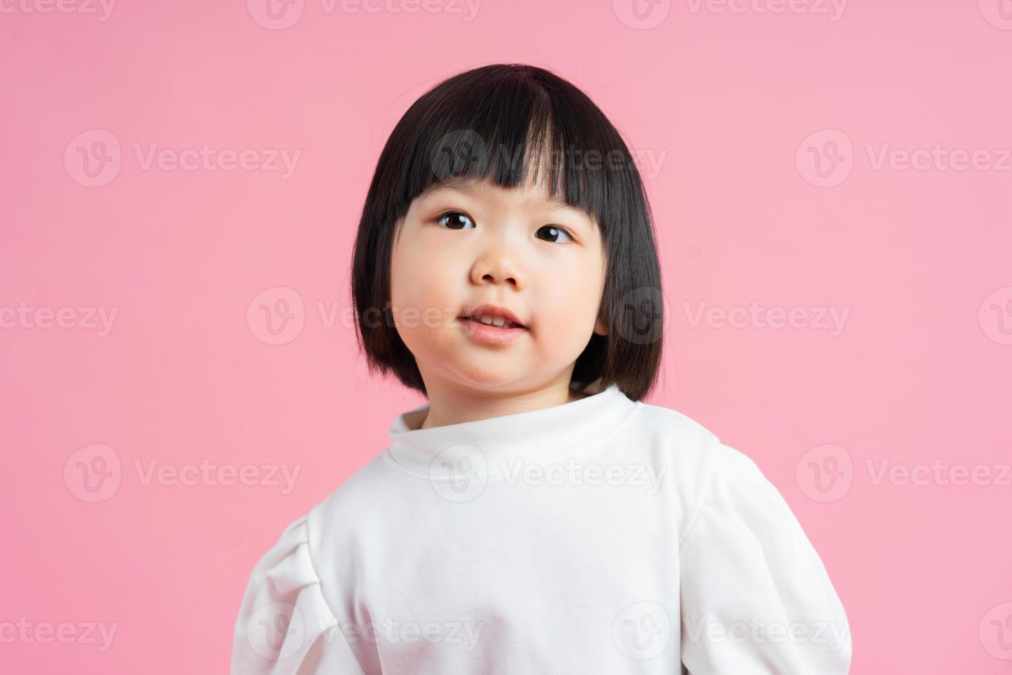 härlig baby flicka porträtt, isolerad på rosa bakgrund foto