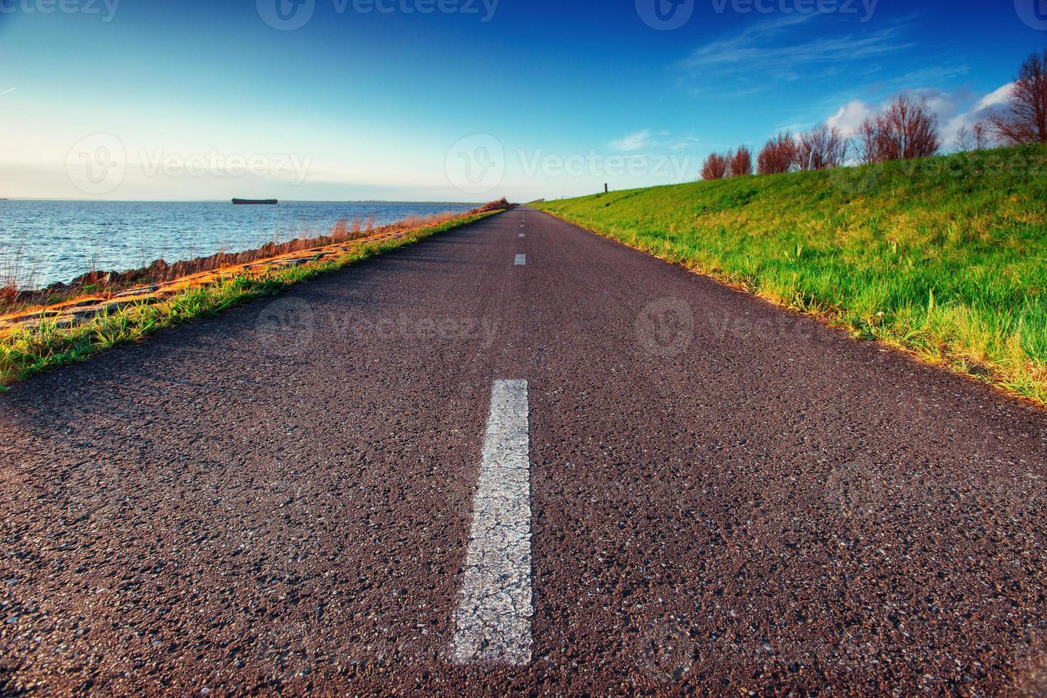 asfalterad väg längs havet i en fantastisk sommardag foto