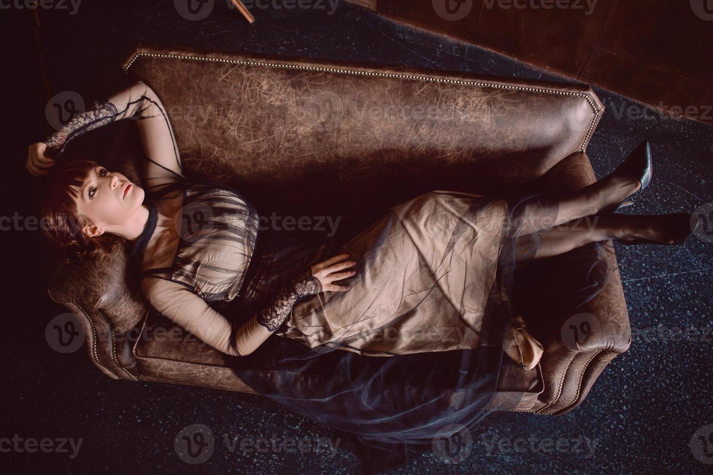 kvinna i vintage klänning inomhus på soffan foto