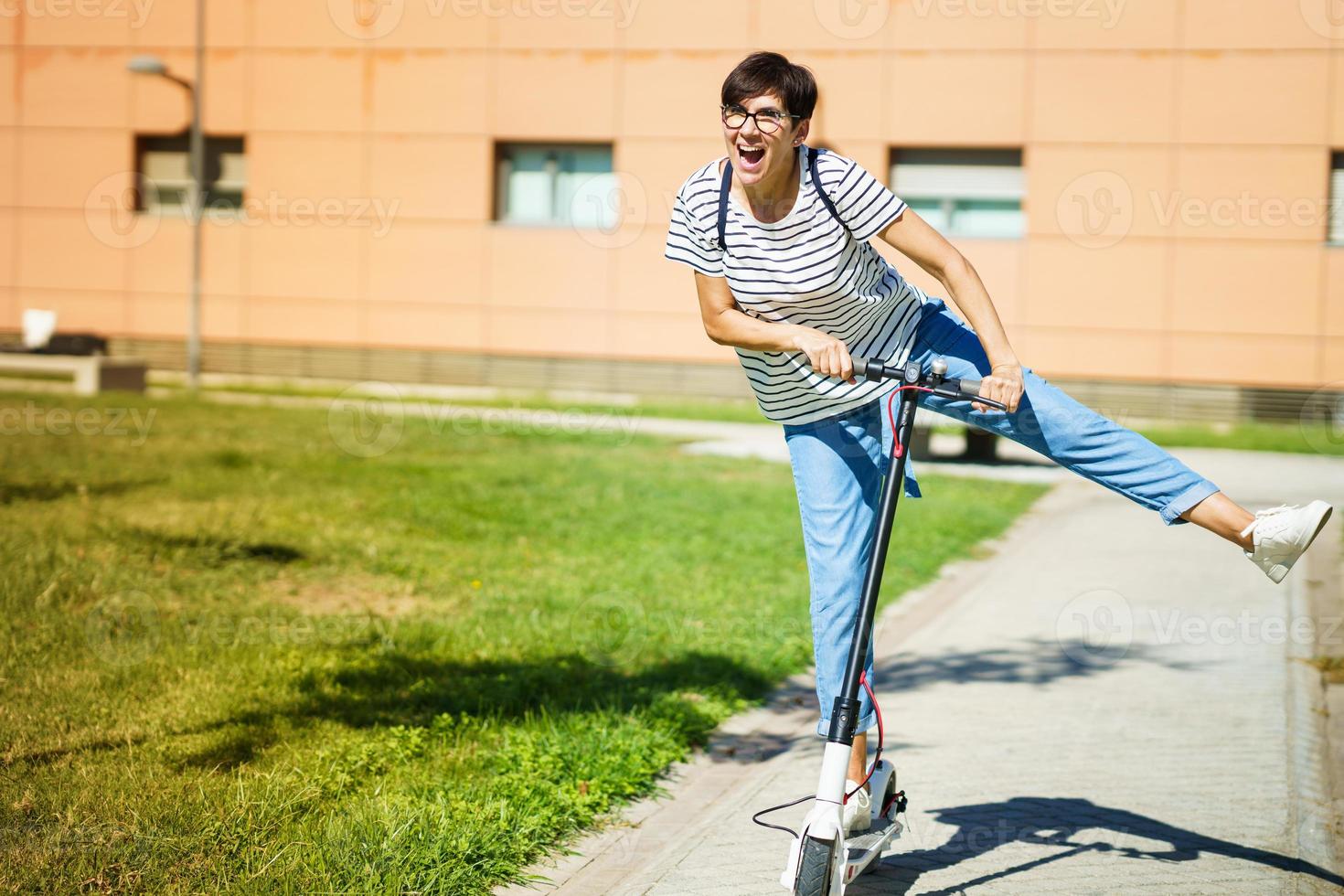 kvinna åker runt i stan på en elektrisk skoter foto