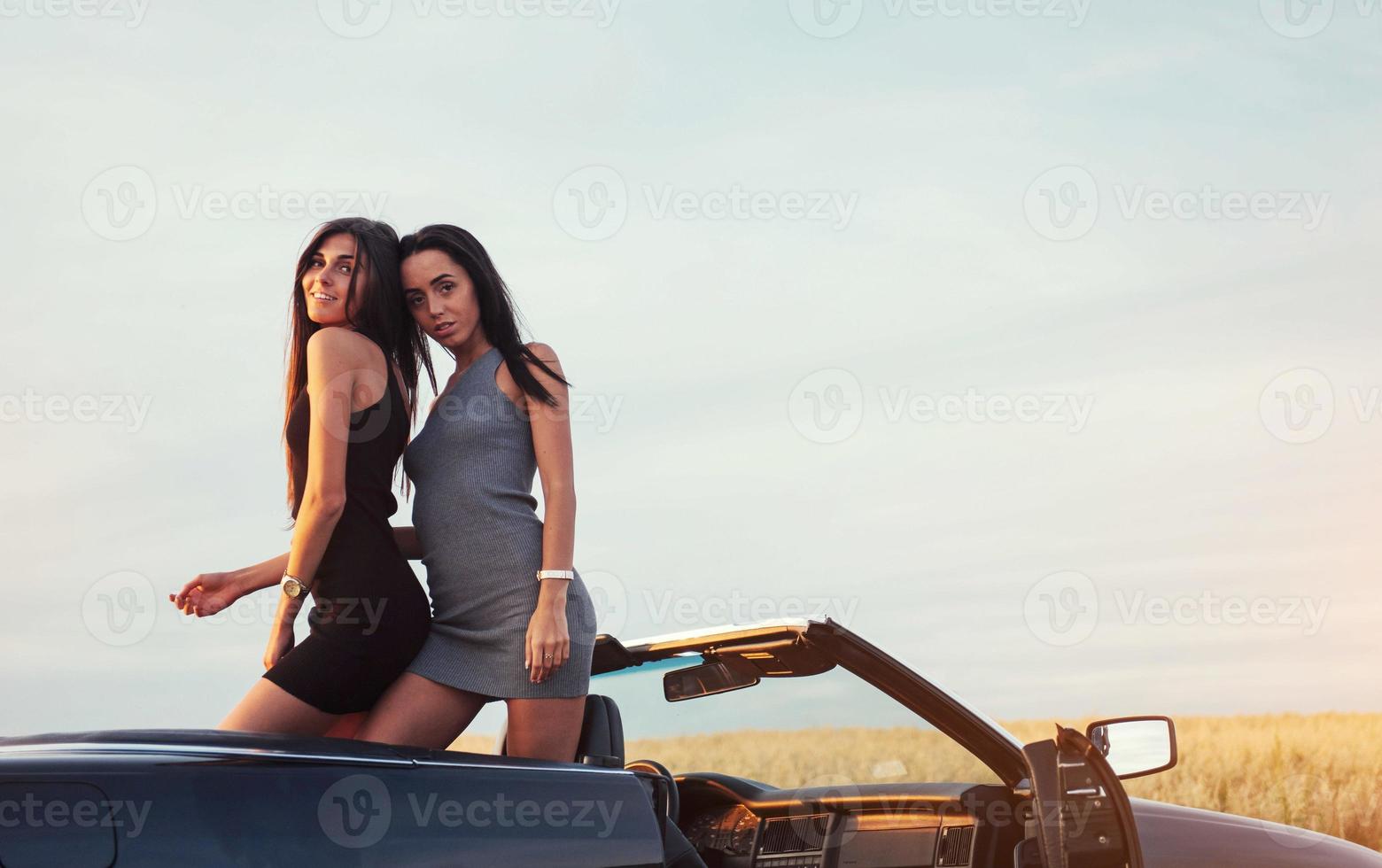 två kvinnor i en svart bil på vägarna foto