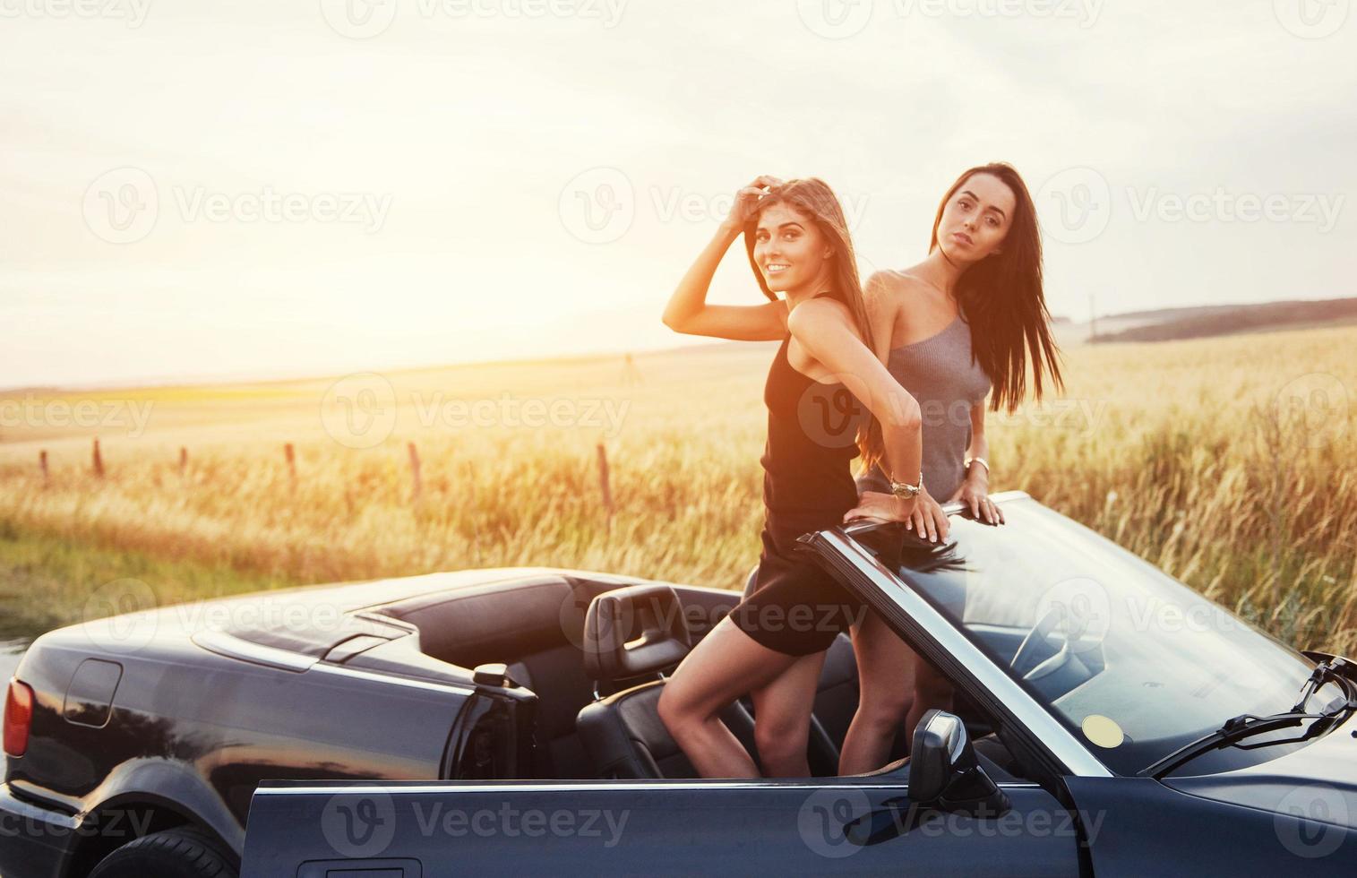 två kvinnor i en svart bil på vägarna foto
