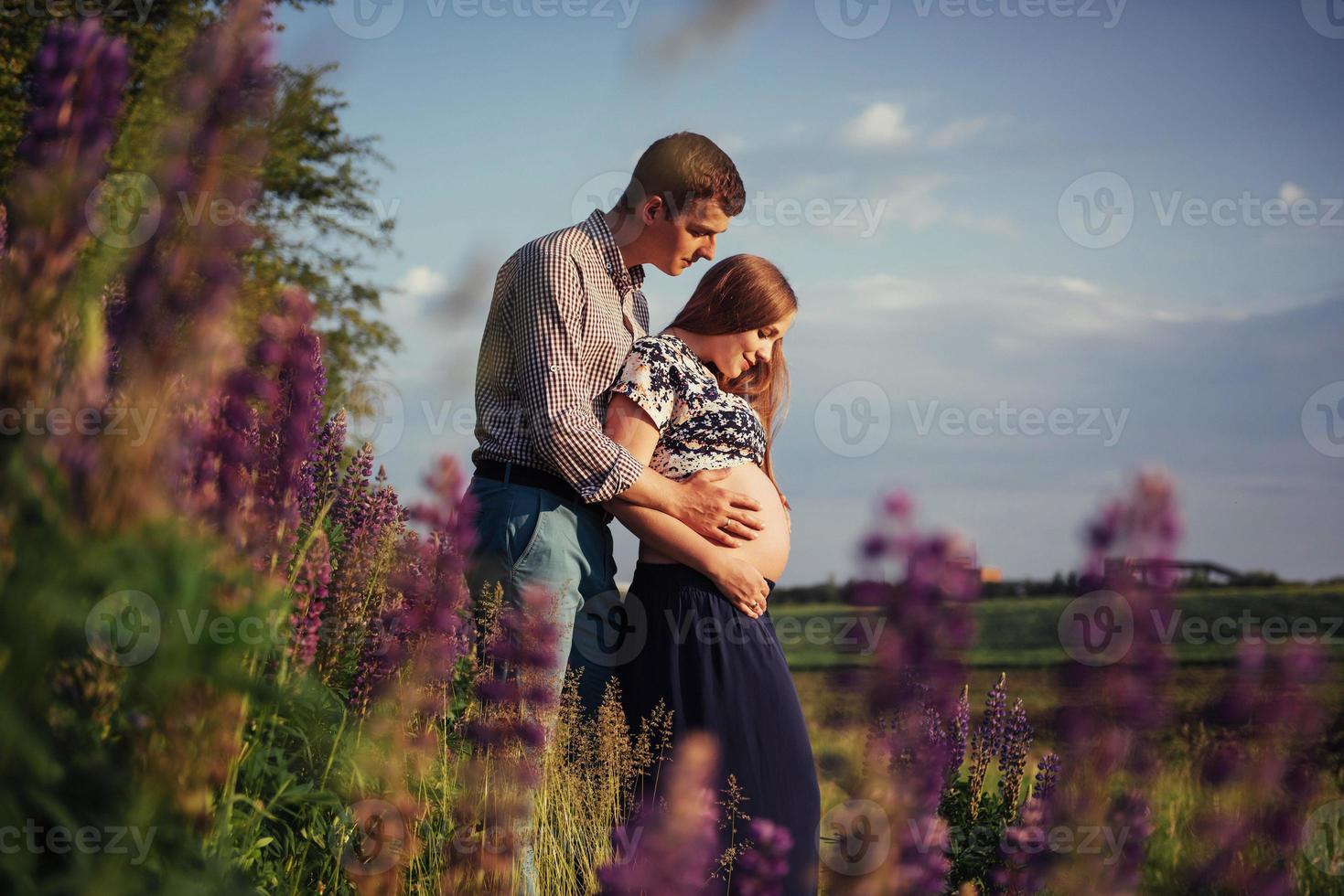 glad vacker flicka gravid med sin man utomhus. foto