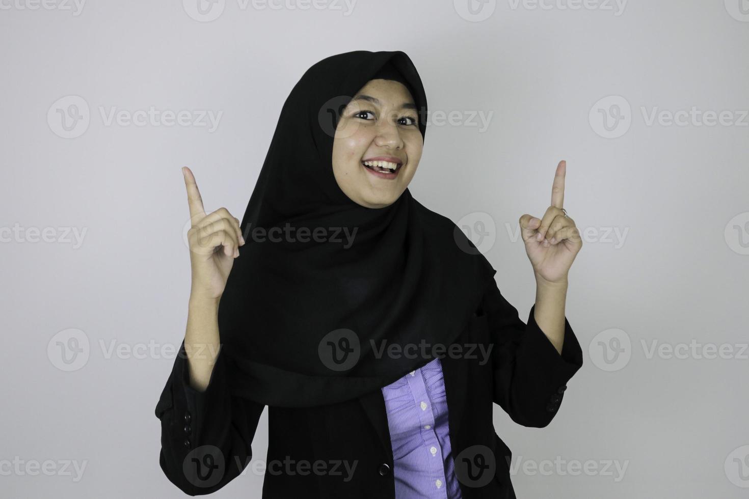 glada asiatiska islamiska affärskvinnor som pekar ovan foto
