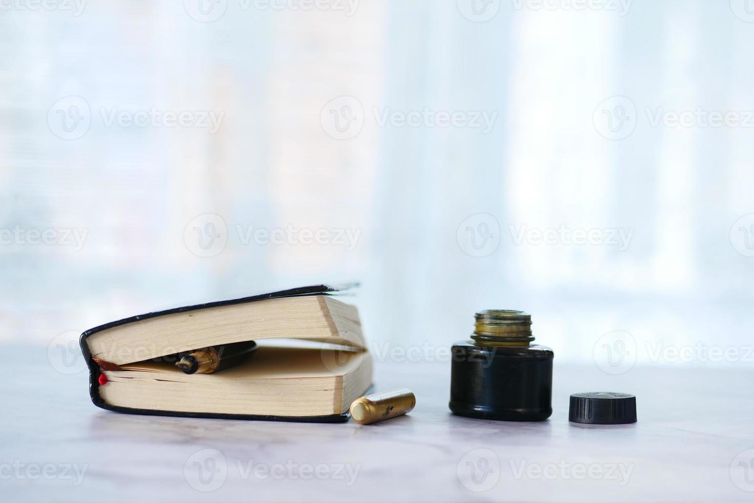 bläck, tomt papper och reservoarpenna på bordet foto