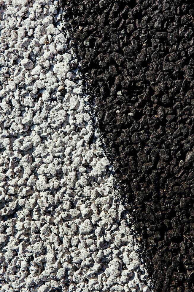 asfaltväg svart med vita markeringar. makrofotografering foto