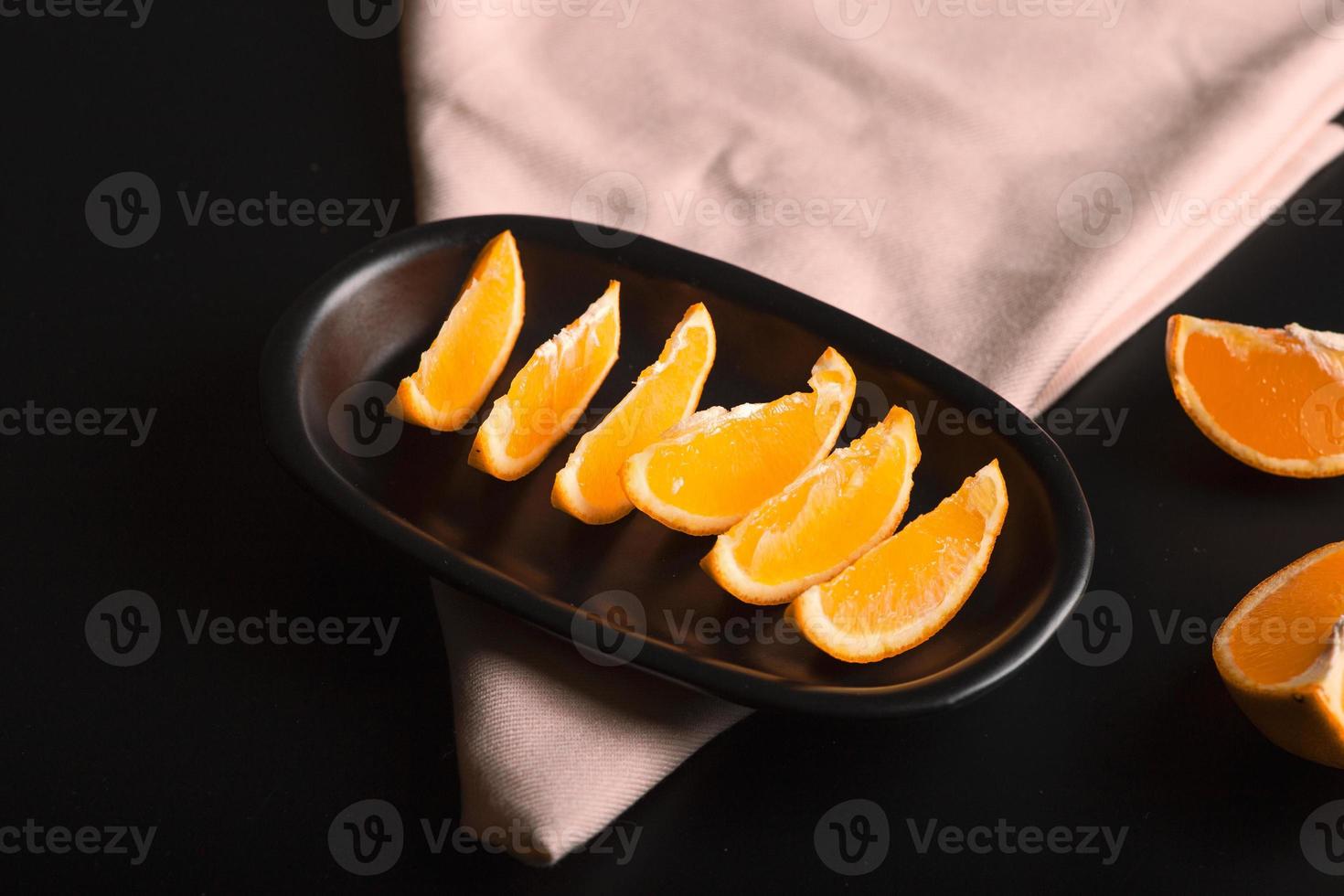 skivad apelsin citrusvy över svart bakgrund, inkluderar kopieringsutrymme. foto