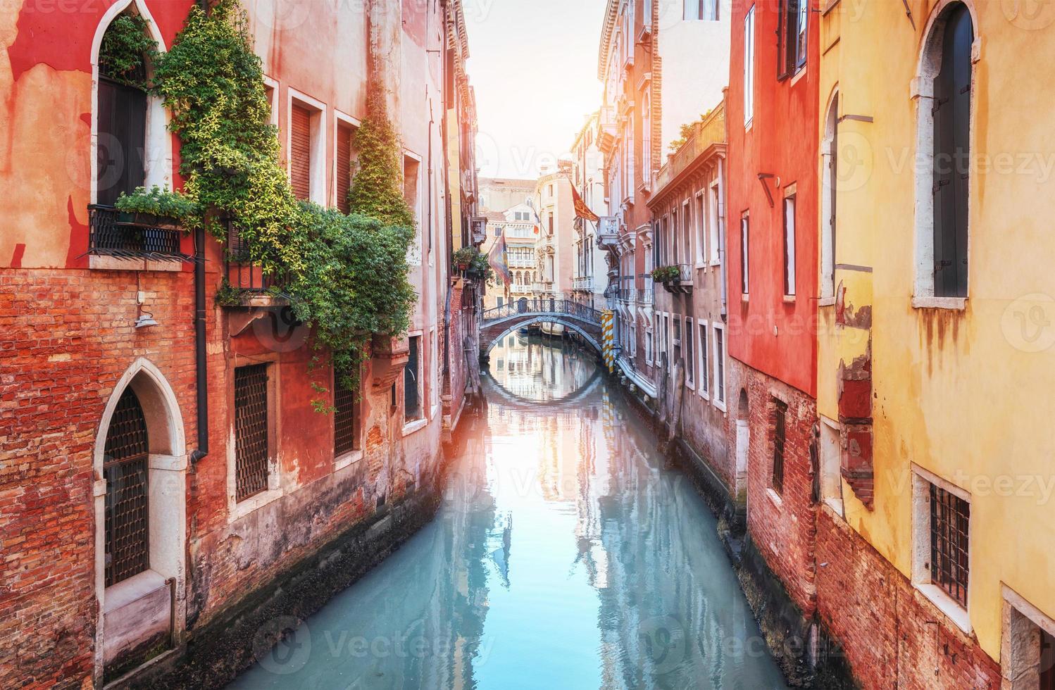 traditionella gondoler på smal kanal mellan färgglada historiska hus i Venedig, Italien foto