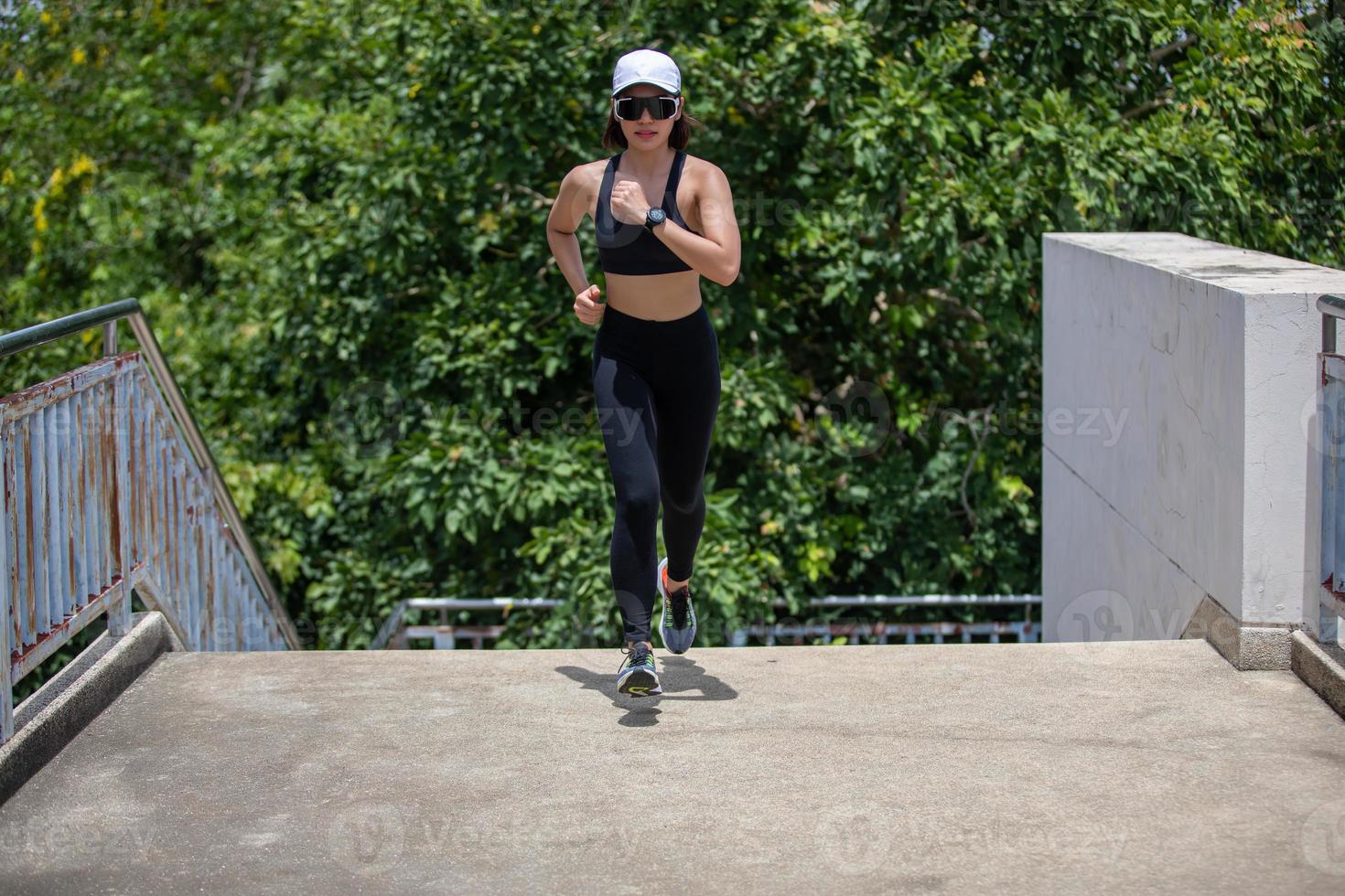 asiatiska kvinnor springer och joggar under utomhus på city run foto