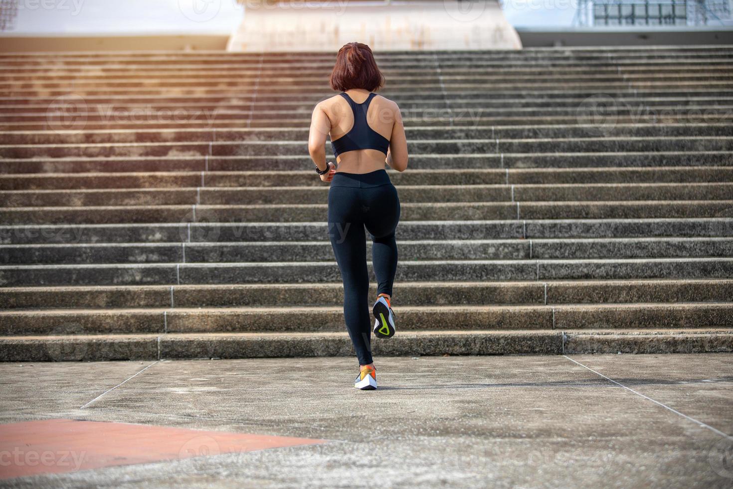 asiatiska kvinnor springer och joggar under utomhus på city run foto