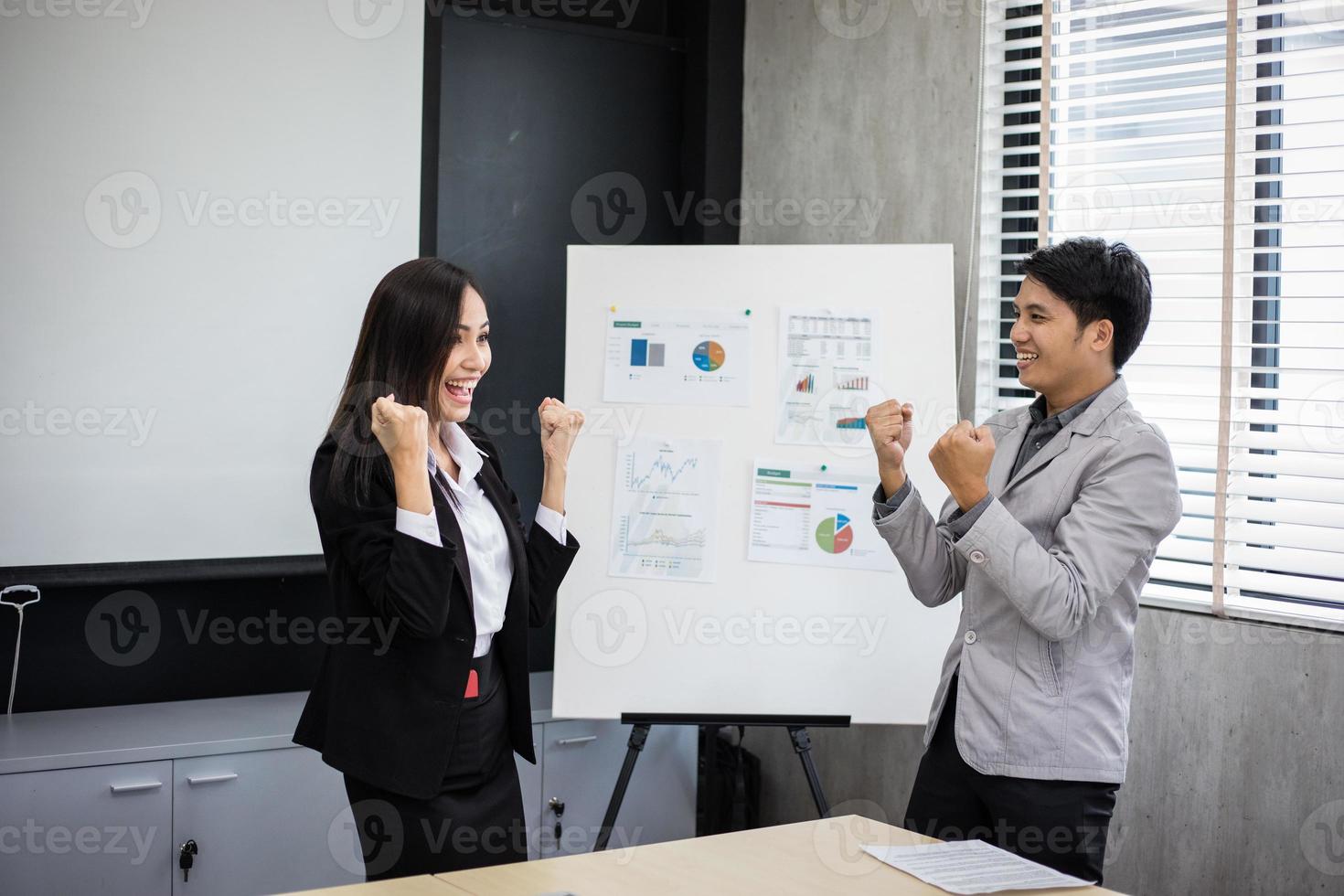 asiatiska affärsmän och affärskvinnor framgång och vinnande koncept - lyckligt team med upphöjda händer som firar genombrottet och prestationerna foto