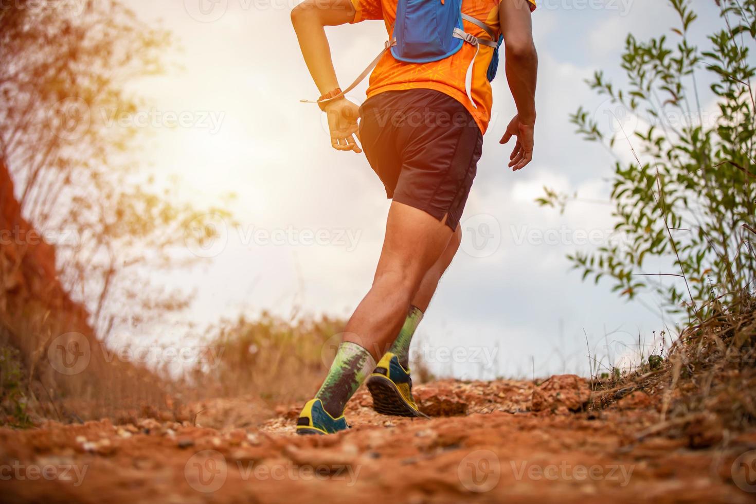 en man löpare av trail och atlets fötter bär sportskor för trail löpning i berget foto