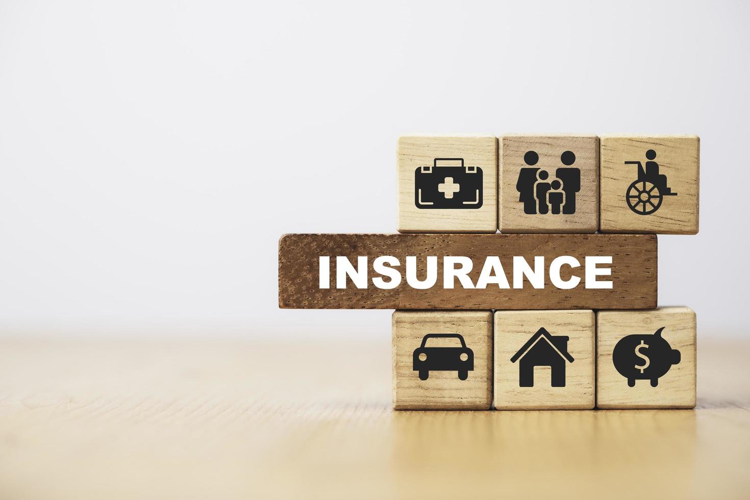försäkring och försäkran ikon inklusive familj hälsa fastigheter bil och finansiell utskrift skärm på trä kub bock för riskhantering koncept. foto