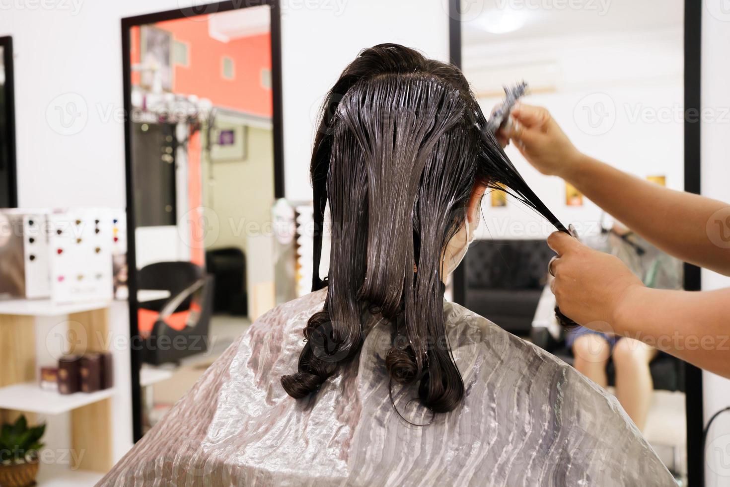 professionell frisör som gör en hårfärgning och behandling i skönhets- och salongsbutik. kvinna som ändrar en hårfärg i professionell salongbutik. foto
