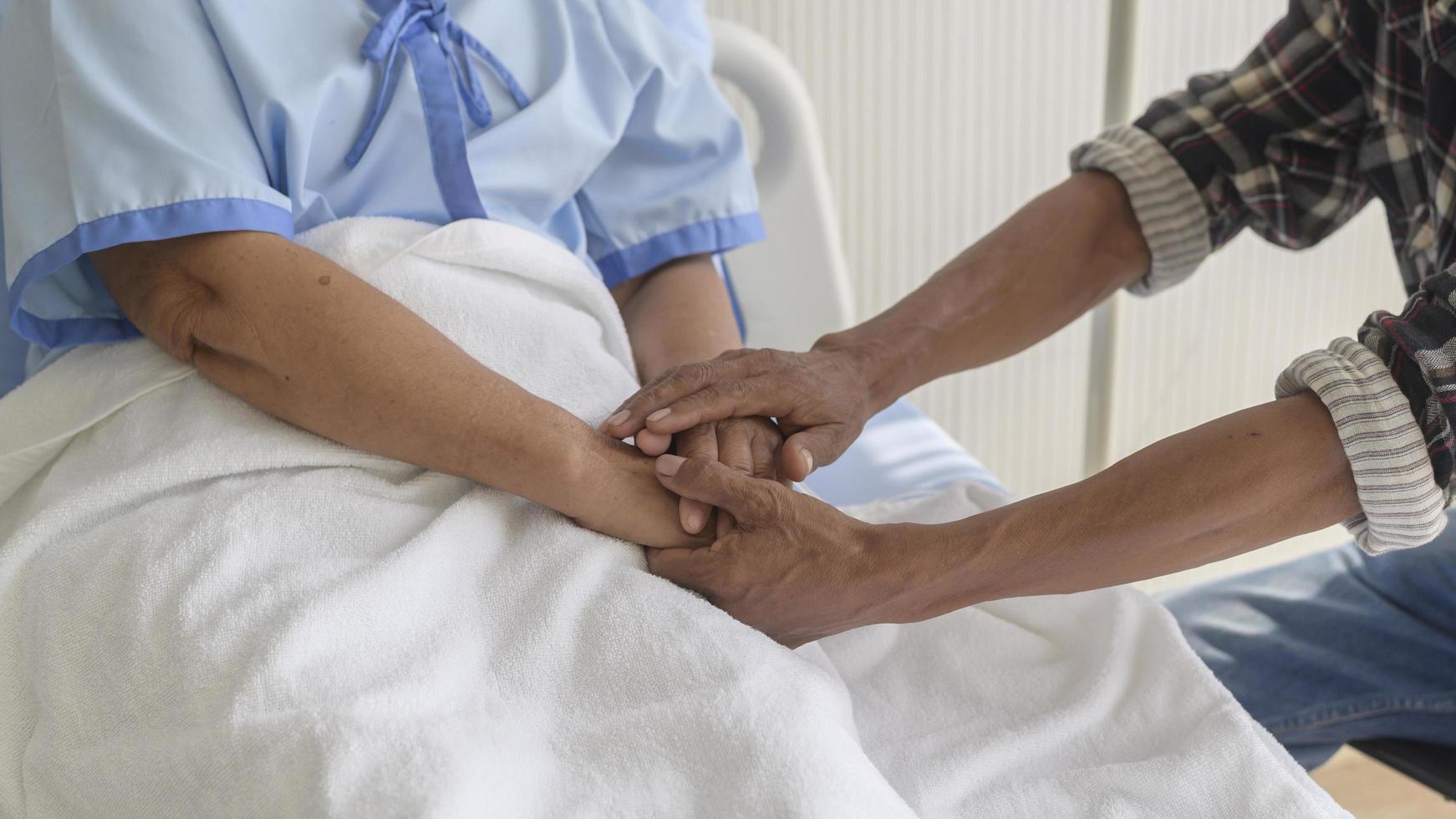 senior man besöker senior patient kvinna på sjukhus, hälsovård och medicinsk koncept foto