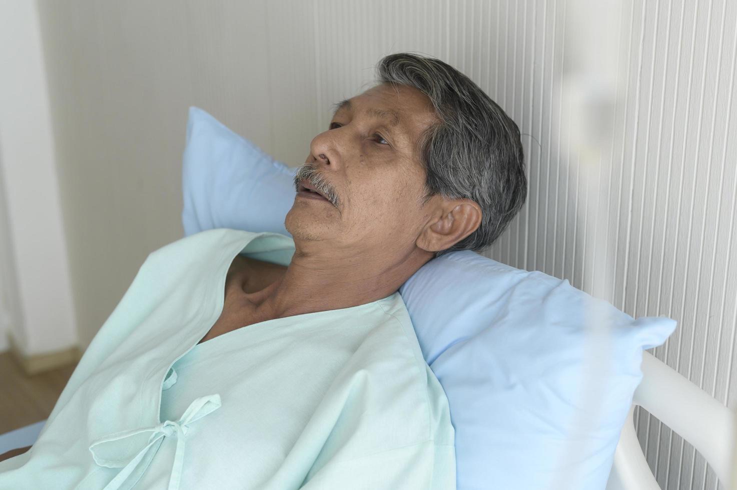 porträtt av senior patient liggande på sängen på sjukhus, sjukvård och medicinsk koncept foto