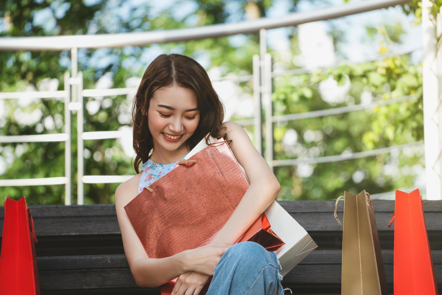 asiatisk ung kvinna kram shoppingkassar foto