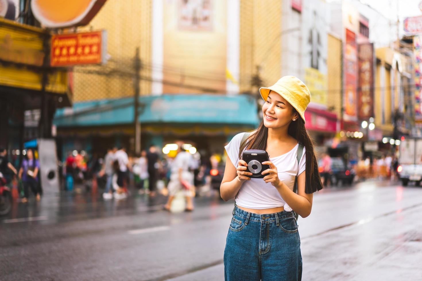 asiatisk resenär kvinna håller omedelbar kamera foto
