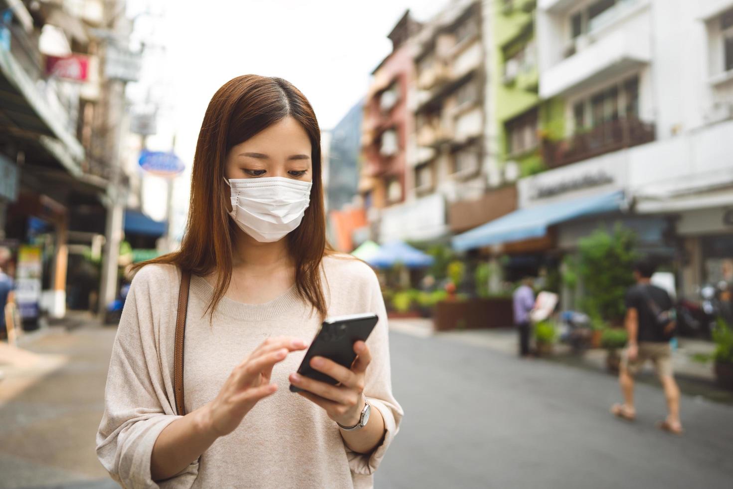 affärsung asiatisk ensamstående kvinna bär ansiktsmask för skyddande coronavirus eller covid 19 foto