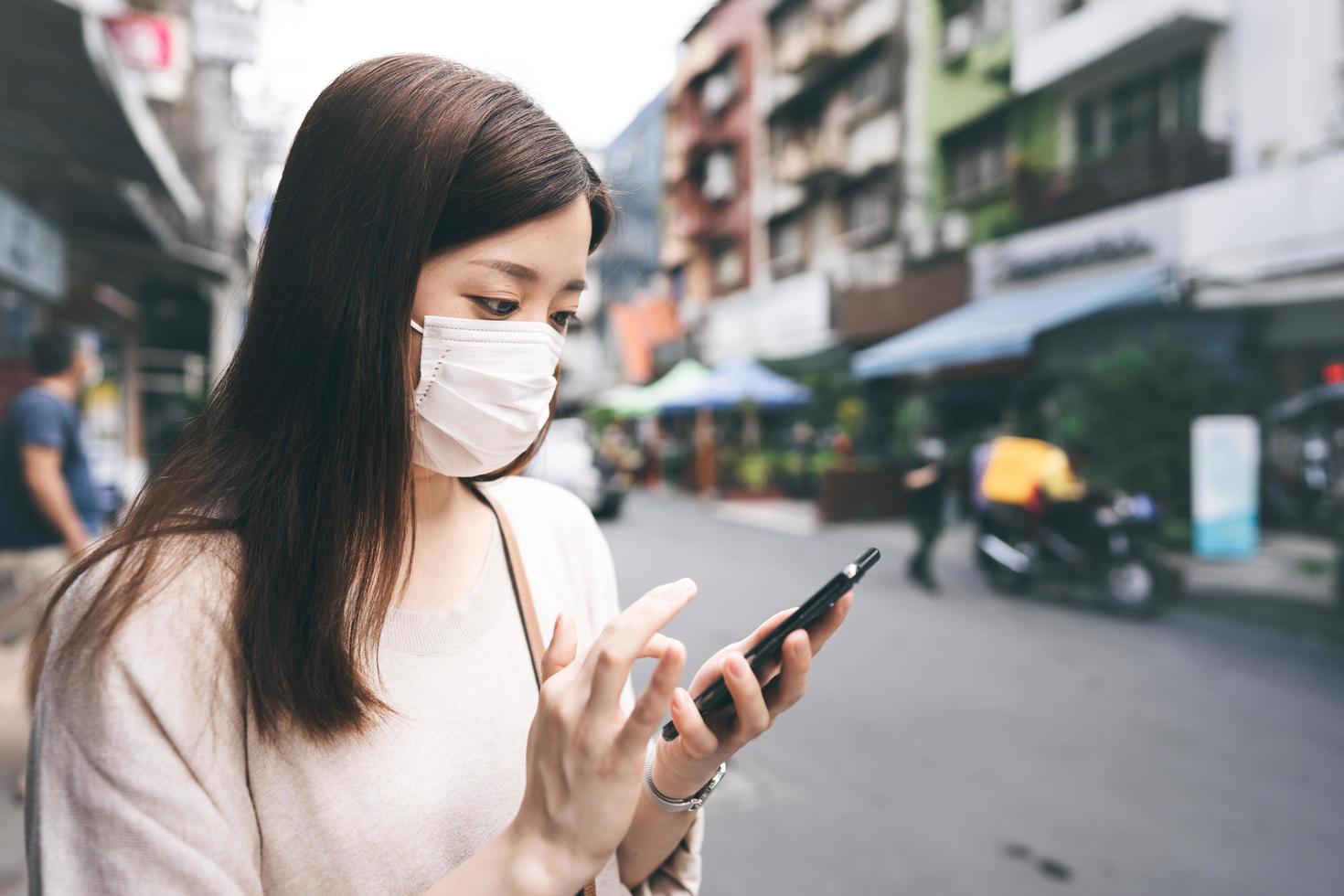 affärsung asiatisk ensamstående kvinna bär ansiktsmask för skyddande coronavirus eller covid 19 foto