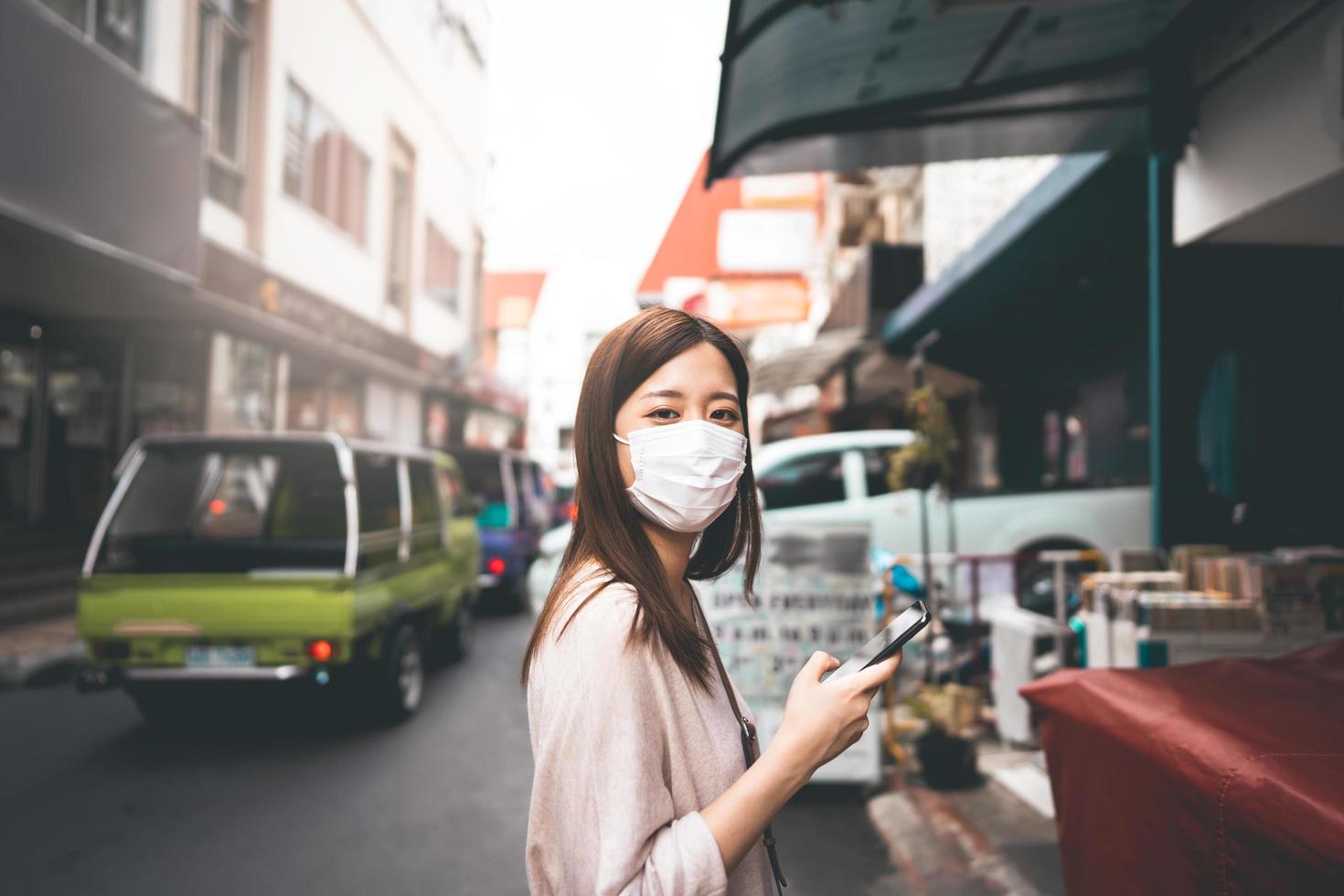 affärsung asiatisk ensamstående kvinna bär ansiktsmask för skyddande coronavirus eller covid 19 foto