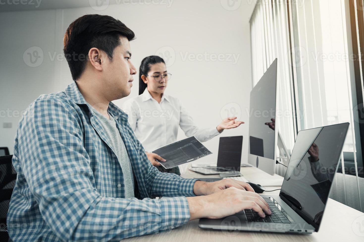 två asiatiska team som arbetar med utveckling av programmering och krypteringsteknik webbdesign programmerare på skrivbordet på kontoret. foto