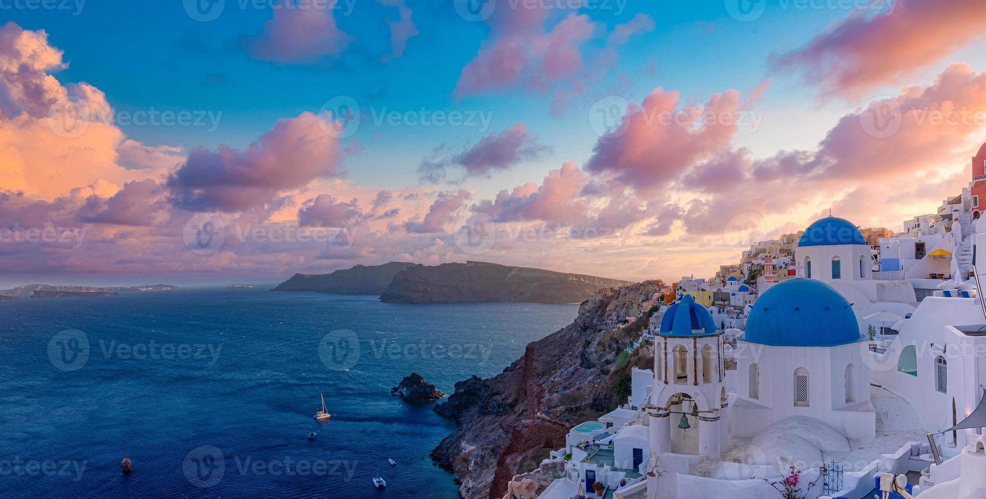 fantastiskt solnedgångslandskap av berömda rese- och semestermål. lyxigt sommaräventyrskoncept. underbar utsikt över byn Oia, Santorini, Grekland. hotell med pooler och fantastisk arkitektur foto